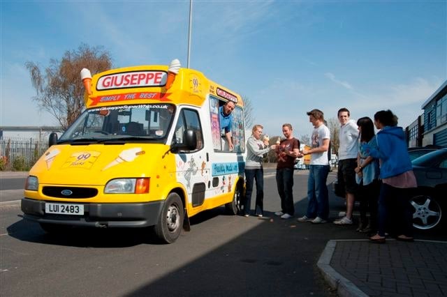 ice cream van with a queue of people waiting